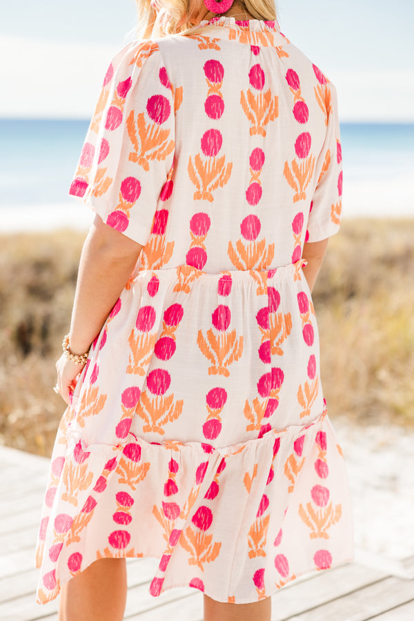 Chic Soul plus size clothing, short-sleeve white flowy baby doll dress with a split-v-neckline and tassels with a hot pink pom at the end with a hot pink and orange abstract striped pattern 