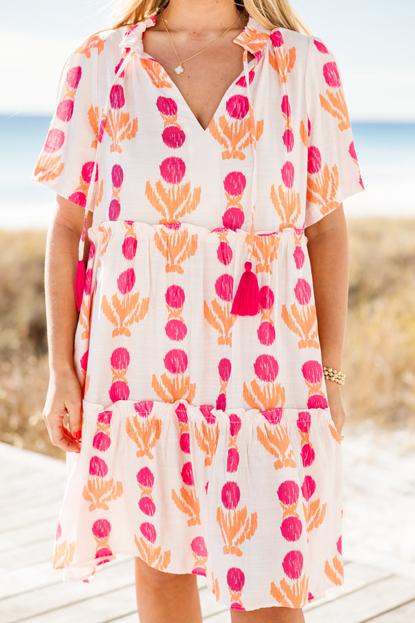 Chic Soul plus size clothing, short-sleeve white flowy baby doll dress with a split-v-neckline and tassels with a hot pink pom at the end with a hot pink and orange abstract striped pattern 
