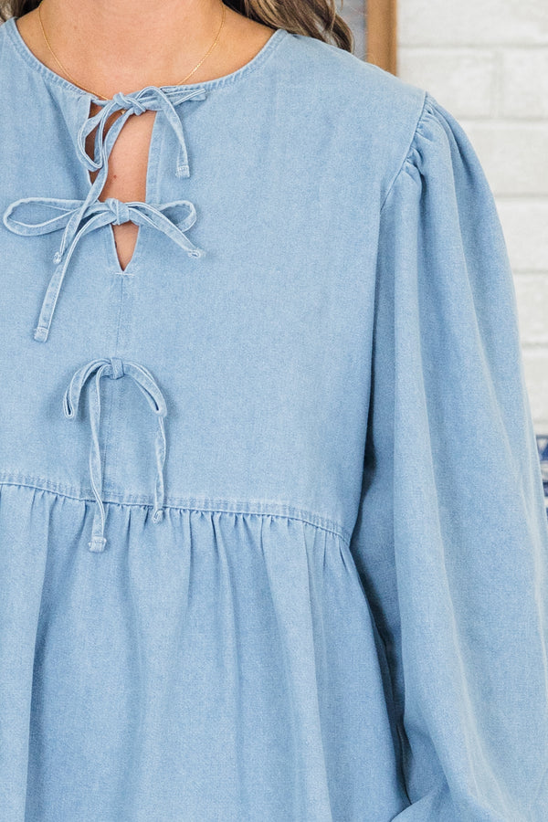 Plus Size light denim babydoll dress with a split v-neck, front bow details, and balloon sleeves.