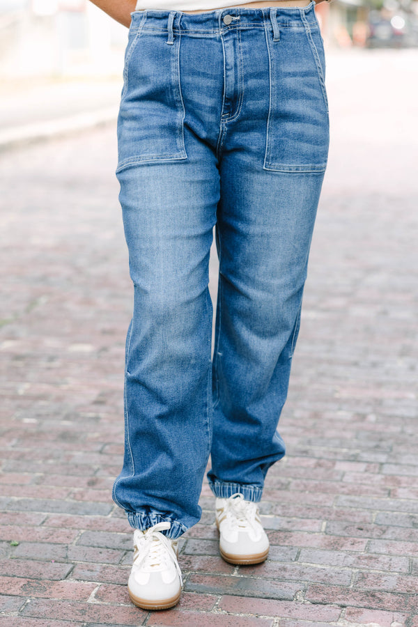 Plus Size medium wash high-rise cargo jogger jeans with front patch pockets and elasticized cuffs.