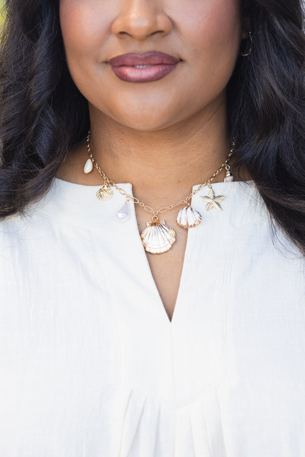 Chic Soul plus size clothing, gold necklace with various seashell charms hanging of the gold chain 