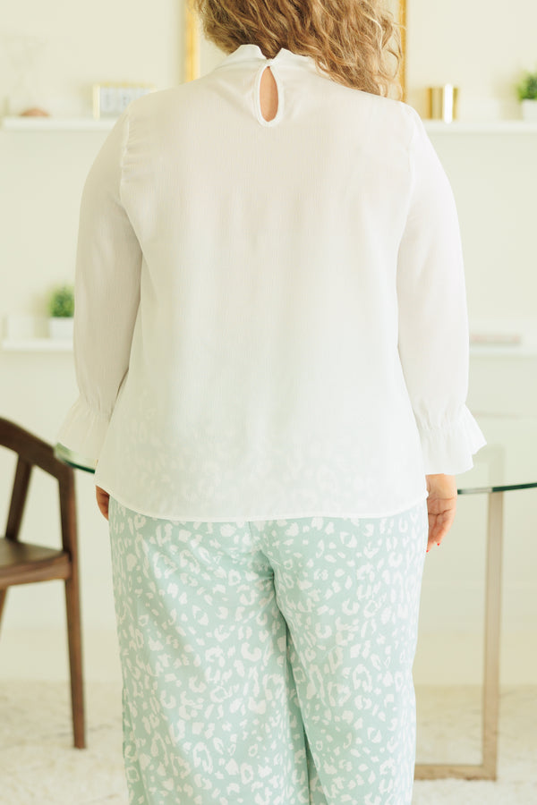Plus Size white high-neck top with ruffled collar and cuffs paired with mint leopard print pants.