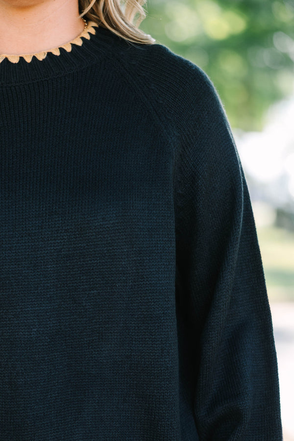 Plus size black knit sweater with tan scalloped trim on the crew neck, cuffs, and hem.