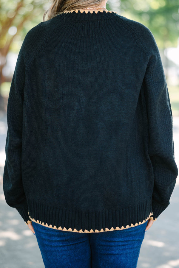 Plus size black knit sweater with tan scalloped trim on the crew neck, cuffs, and hem.