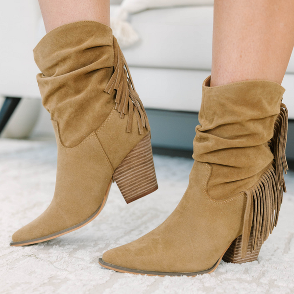Tan suede-like booties with a slouchy shaft, fringe detail, and stacked block heel.
