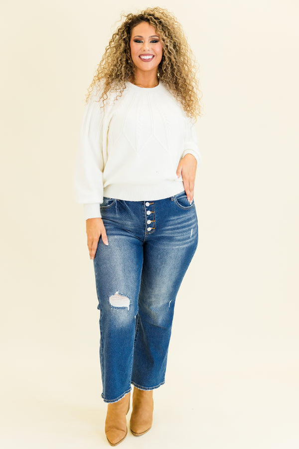 mid-waisted subtle flare cropped dark wash denim jeans with slight distressed detailing along knees and multiple silver buttons on waistline 
