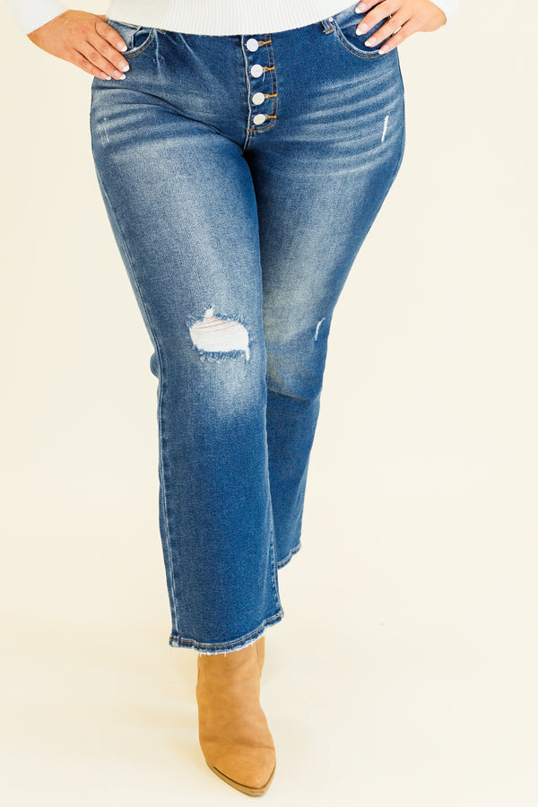 mid-waisted subtle flare cropped dark wash denim jeans with slight distressed detailing along knees and multiple silver buttons on waistline 
