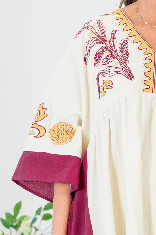 Chic Soul plus size clothing, white elbow length sleeve dress with fuchsia border detail along sides and sleeves with embroidered yellow and fuchsia print along v neckline and chest and sleeves with pockets