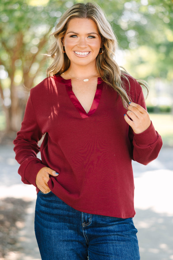 Plus Size burgundy long sleeve top with a ribbed texture and a satin-trimmed v-neckline.