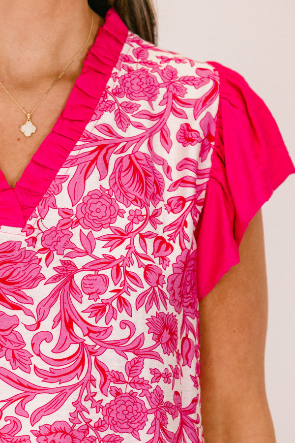 Plus Size pink floral print top with flutter sleeves and a ruffled V-neckline.