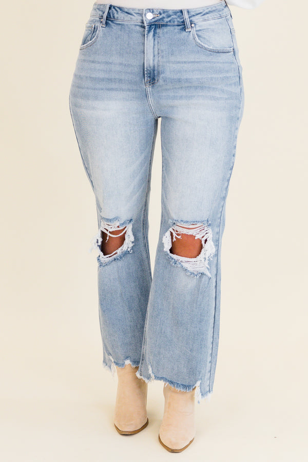 Chic Soul plus size clothing, light wash denim jeans with slight flare at the bottom with holes and distressing on knees with raw distressed hem at the bottom