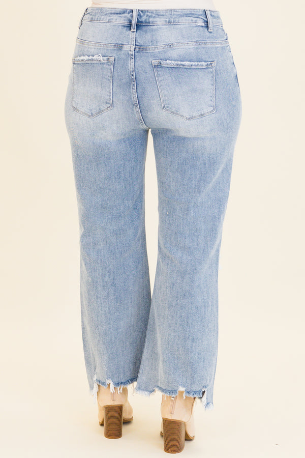 Chic Soul plus size clothing, light wash denim jeans with slight flare at the bottom with holes and distressing on knees with raw distressed hem at the bottom