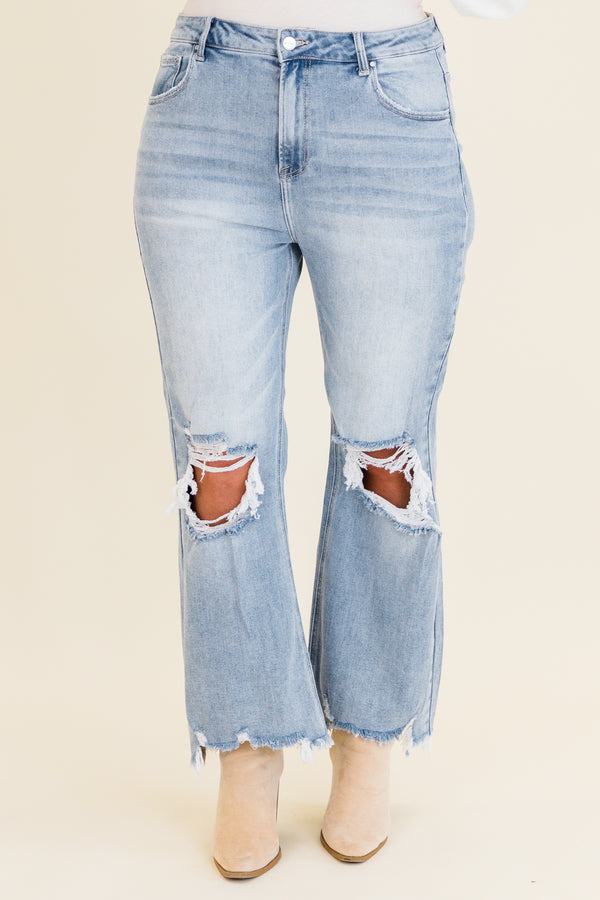 Chic Soul plus size clothing, light wash denim jeans with slight flare at the bottom with holes and distressing on knees with raw distressed hem at the bottom