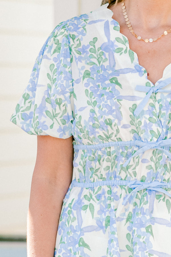 Chic soul plus size clothing, blue short sleeve babydoll top with a floral pattern and a scalloped v-neckline as well as three tie bows going down the  chest 
