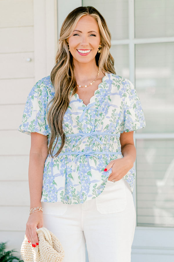 Chic soul plus size clothing, blue short sleeve babydoll top with a floral pattern and a scalloped v-neckline as well as three tie bows going down the  chest 
