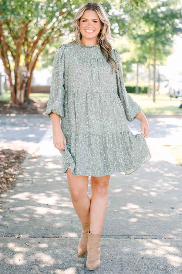 Plus size olive green tiered mini dress with white polka dots and a flowy, relaxed fit.