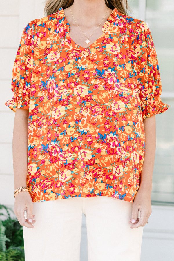 Chic soul plus size clothing, Orange top with three quarter length sleeves, multi-color floral pattern, and a partial ruffle collar 