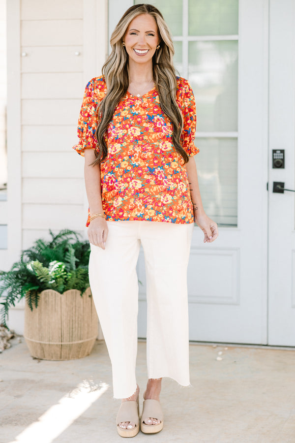 Chic soul plus size clothing, Orange top with three quarter length sleeves, multi-color floral pattern, and a partial ruffle collar 