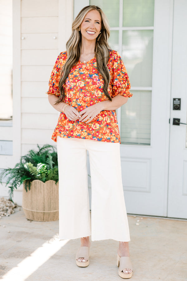 Chic soul plus size clothing, Orange top with three quarter length sleeves, multi-color floral pattern, and a partial ruffle collar 