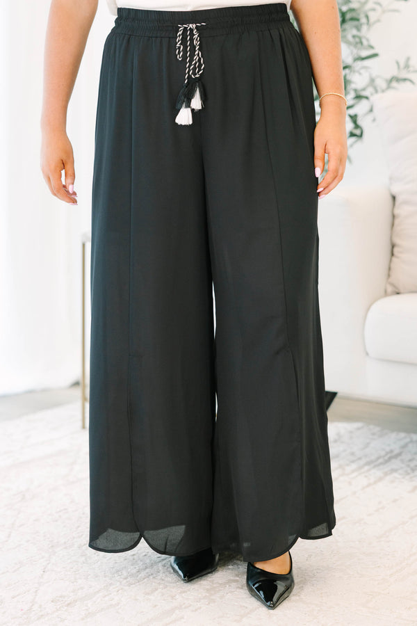 Plus size black wide-leg pants with a flowy fit, smocked drawstring waist, and tassel details.