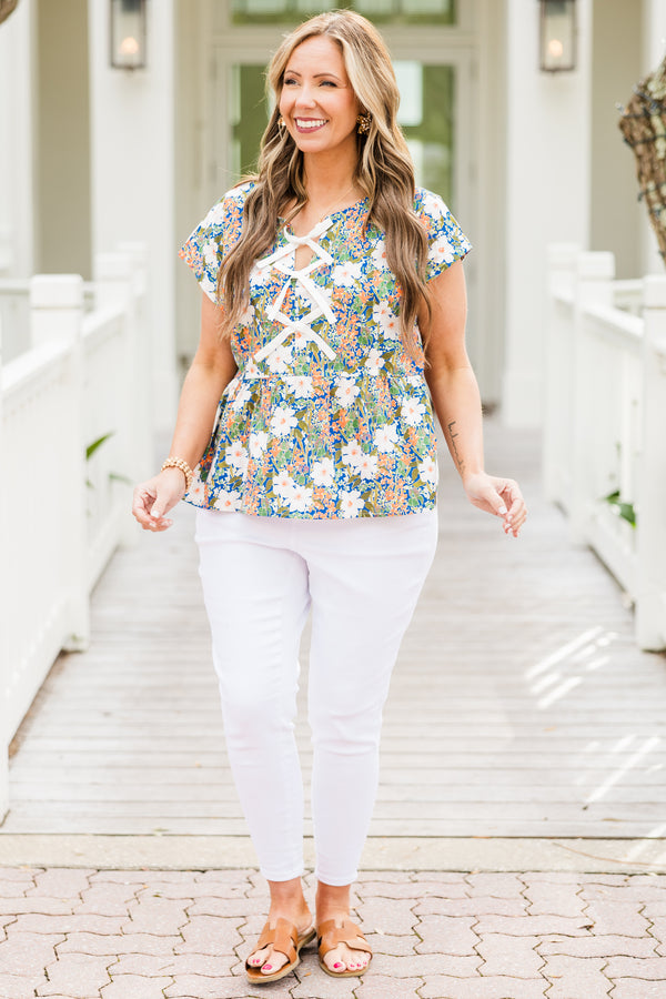 Chic Soul plus size clothing, short-sleeve green baby doll top with a high-scoop-neckline and three white bows tying the front with a green multi-colored floral pattern 