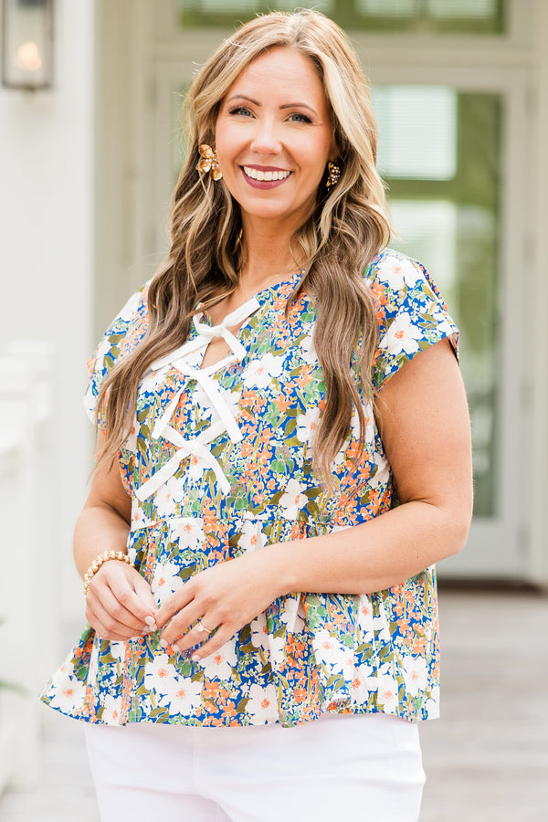 Chic Soul plus size clothing, short-sleeve green baby doll top with a high-scoop-neckline and three white bows tying the front with a green multi-colored floral pattern 