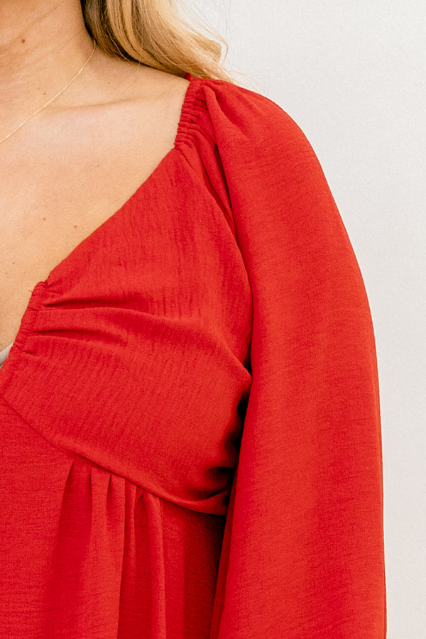 Plus Size red v-neck top with elastic balloon sleeves and a smocked back in a textured fabric.