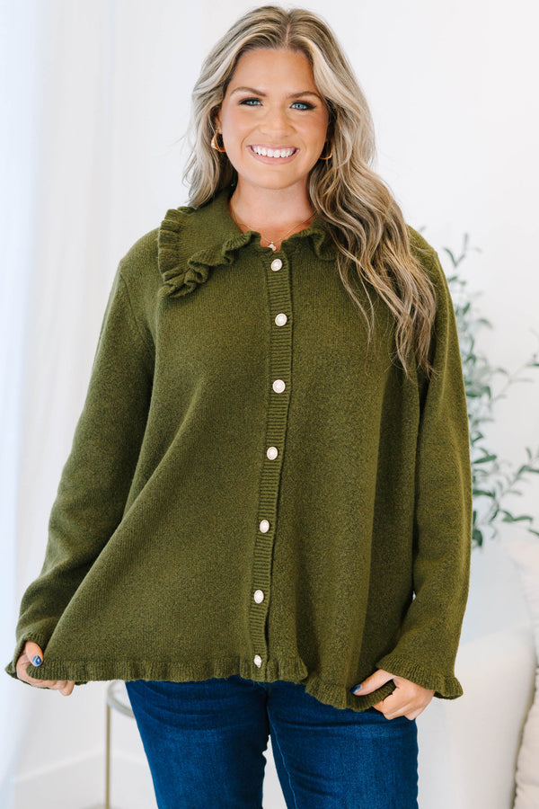 Plus size olive green cardigan with a ruffled collar, pearl buttons, and a flowy, relaxed fit.