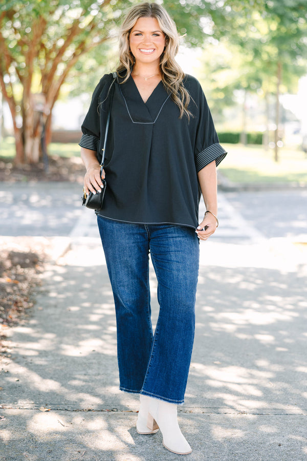 Plus Size black v-neck top with white contrast stitching on the neckline, cuffs, and hem.