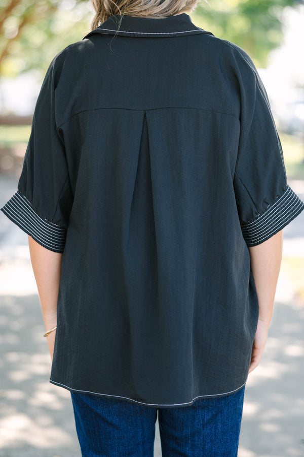 Plus Size black v-neck top with white contrast stitching on the neckline, cuffs, and hem.
