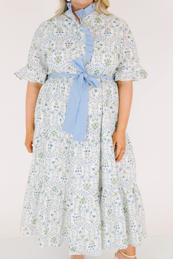 Chic Soul plus size clothing, blue maxi dress with shorts sleeves that flare out a blue multi floral pattern and a blue belt that ties into a bow that goes around the waist as blue ruffling details going along the neckline 