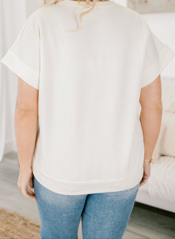 Chic Soul plus size clothing,  short-sleeve ivory top with a textured geometric pattern with subtle raised lines in a diagonal grid design and a high-scoop-neckline