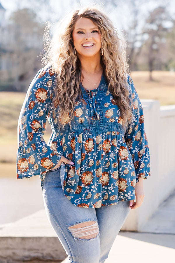Chic Soul plus size clothing, blue flare sleeve long sleeve top with orange/ivory floral design with tie detail on neckline and lace along waist and collar