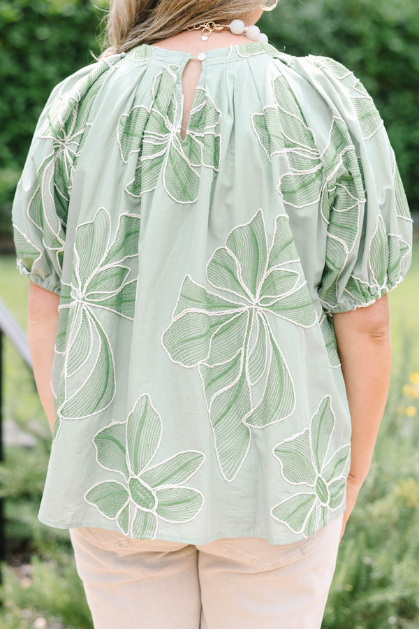 Plus Size olive top with white floral embroidery, elastic puff sleeves, and a round neckline.