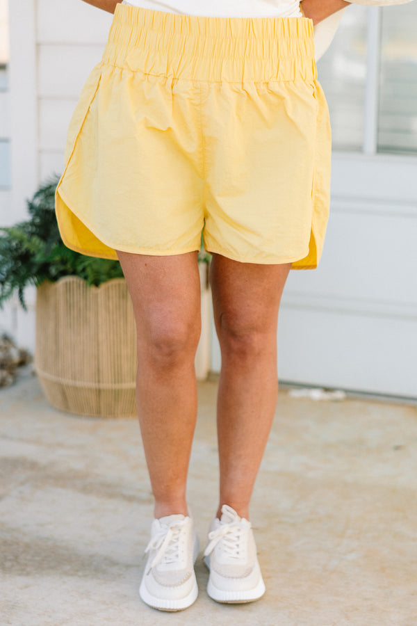 Chic Soul plus size clothing, high-waisted dusty banana yellow athletic shorts with a smocked high-waisted waistband with subtle flaring 