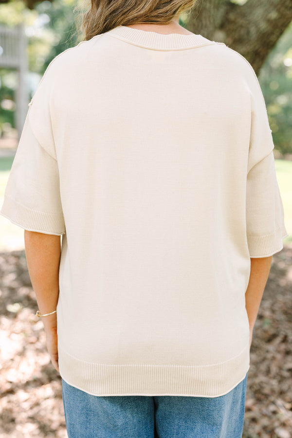 Plus Size cream short sleeve sweater with a brown horseshoe graphic and blue denim jeans.