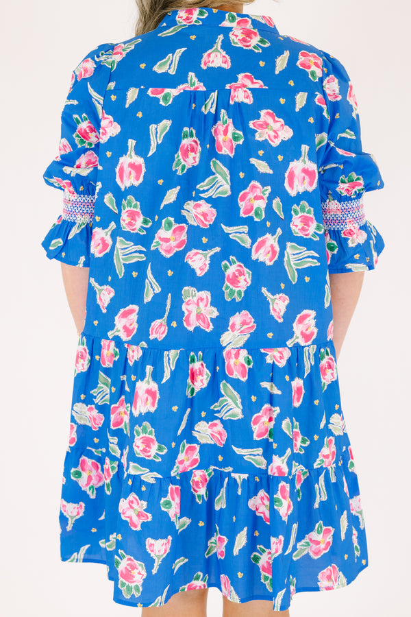 Chic Soul plus size clothing, cobalt tiered knee length dress with half sleeves that have a ruffle flare at the end of each sleeve as well as a pink floral pattern throughout and scalloped detailing on the v-neckline 