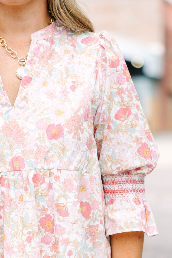 Plus Size pink floral mini dress with a split v-neck, tiered skirt, and smocked bell sleeves.