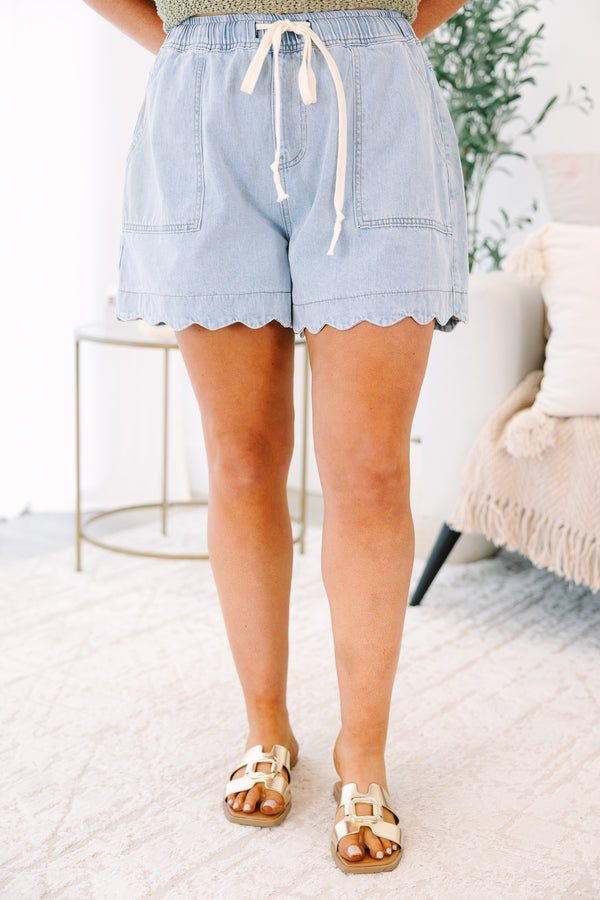 Plus Size light wash denim shorts with an elastic drawstring waist and scalloped hem.