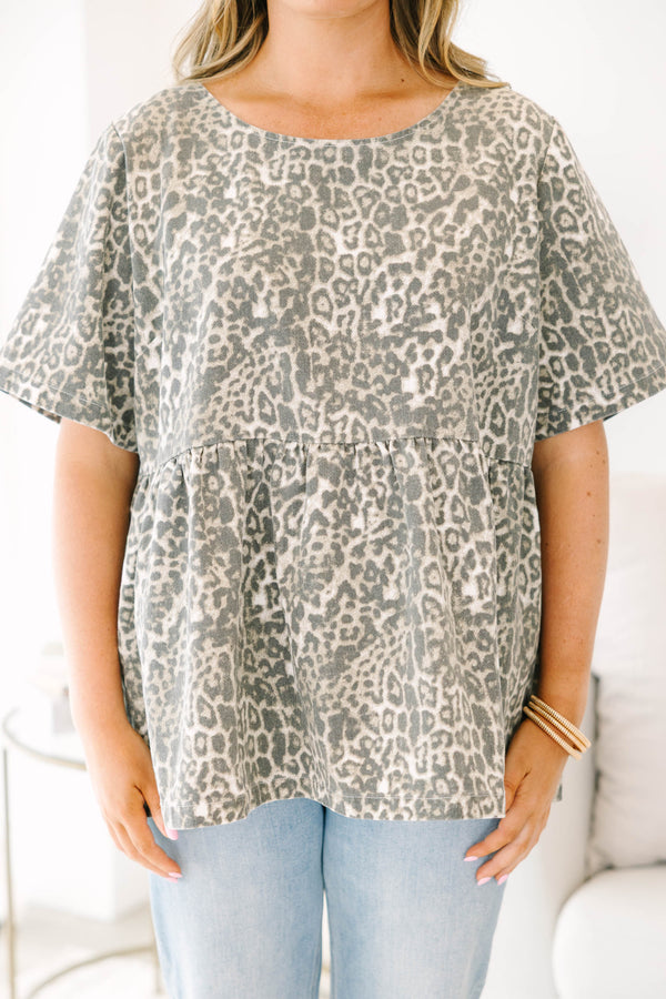 Plus size woman in a light leopard print peplum top with a flowy fit and short sleeves.