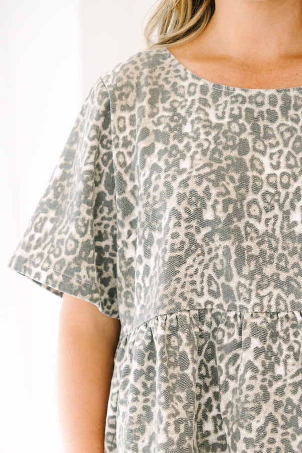 Plus size woman in a light leopard print peplum top with a flowy fit and short sleeves.