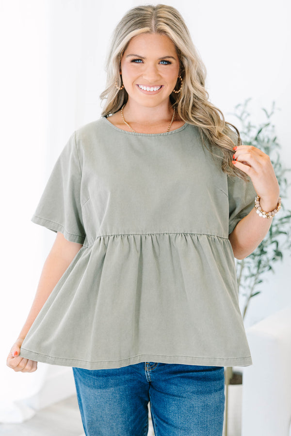 Plus Size olive green short sleeve babydoll top with a round neckline and ruffled waist seam.