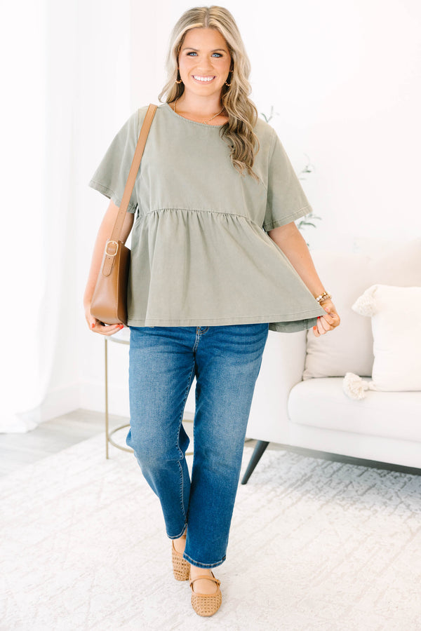 Plus Size olive green short sleeve babydoll top with a round neckline and ruffled waist seam.