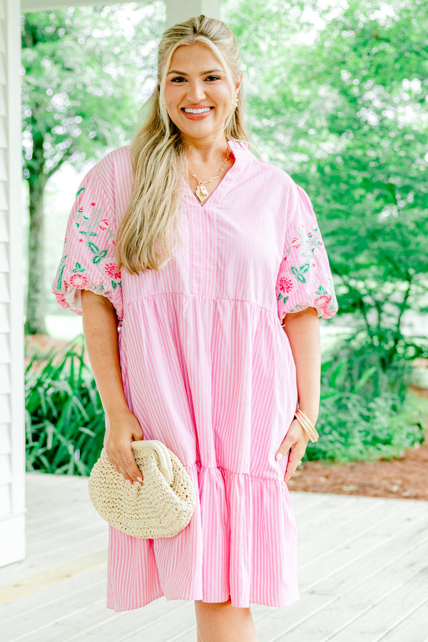 Pink babydoll dress with white stripes, floral embroidered puff sleeves, and a split V-neckline.