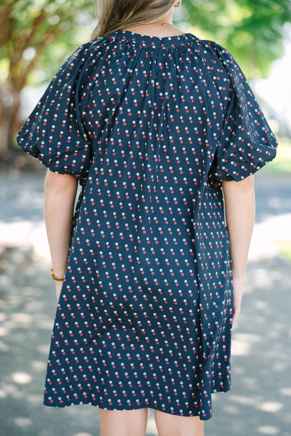 Plus size navy shift dress with red and white polka dots, featuring a flowy fit and V-neckline.