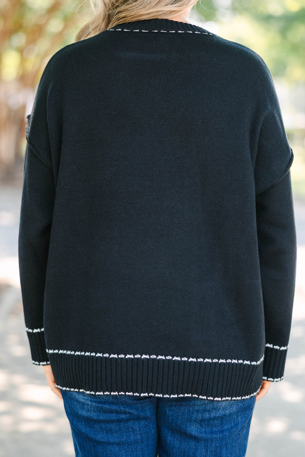 Plus size black knit sweater with white contrast stitching on the neckline, cuffs, and hem.