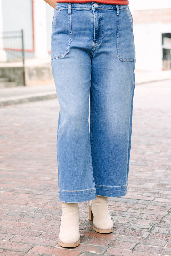 Plus Size medium wash wide-leg cropped jeans with functional pockets and a relaxed fit.