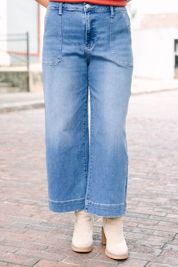 Plus Size medium wash wide-leg cropped jeans with functional pockets and a relaxed fit.