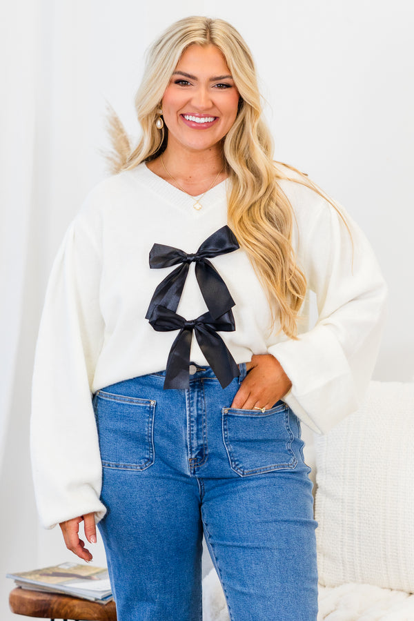 Chic Soul plus size clothing, white long sleeve knit sweater with v neckline with two black satin bows on the front with bubble sleeves