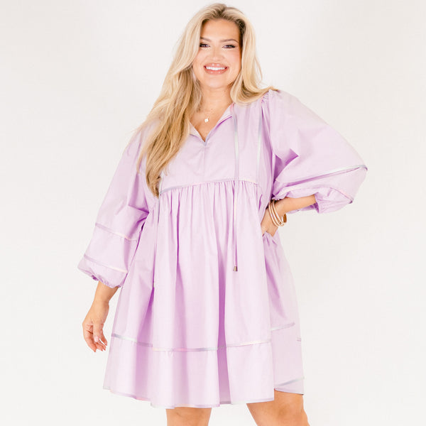 Plus Size lilac flowy mini dress with ombre contrast piping, puff sleeves, and a v-neckline.